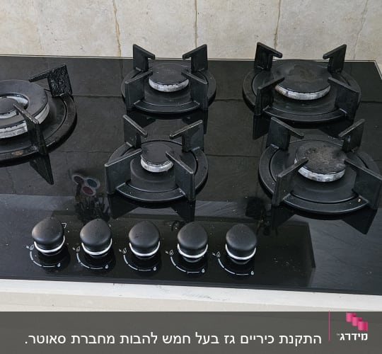 כיריים גז שחורות עם חמישה מבערים וכפתורי שליטה